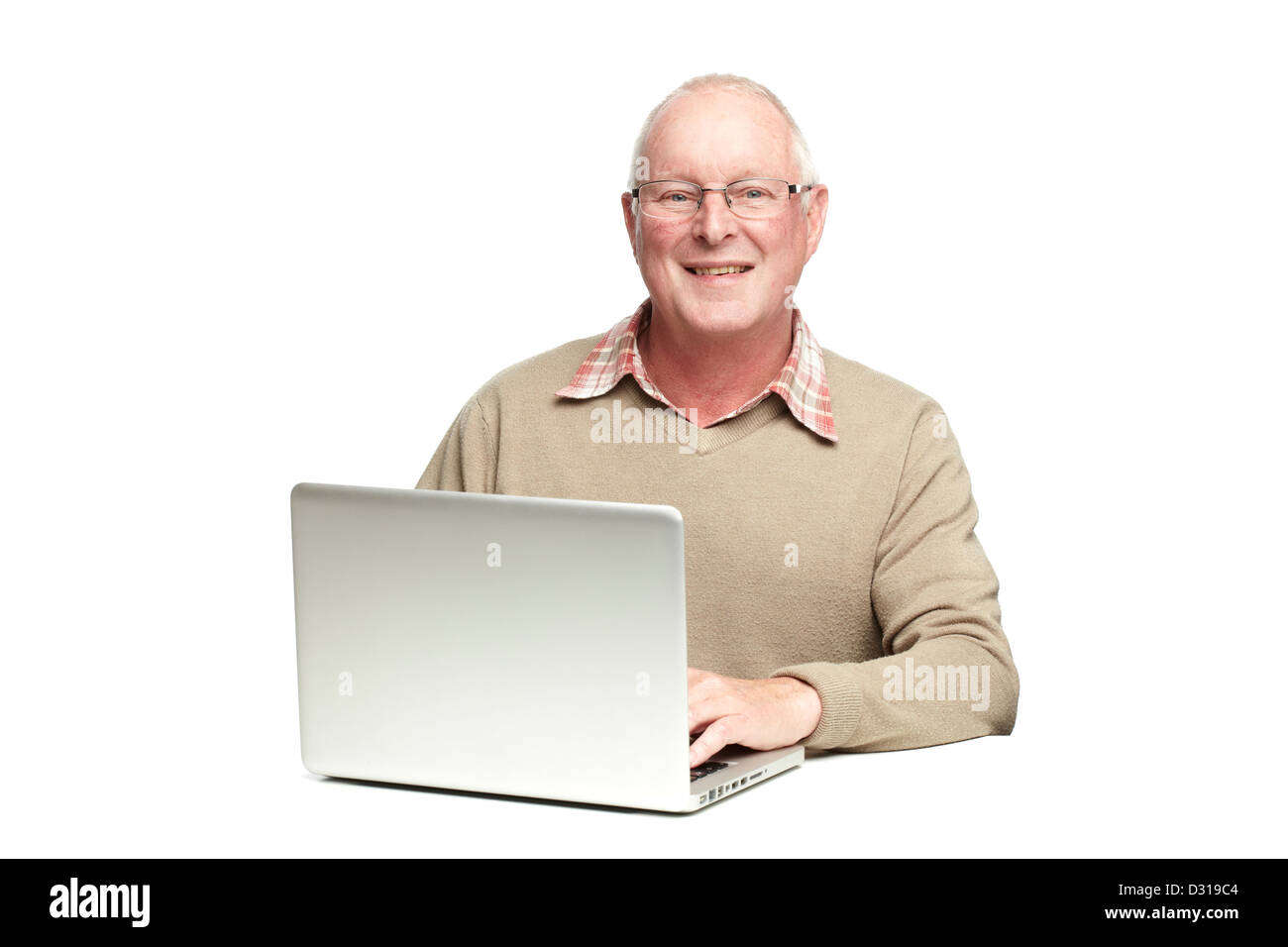 Senior man using laptop whilst smiling, on white background Stock Photo