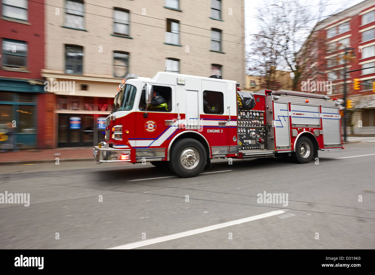 Vancouver fire rescue services truck engine 2 speeding through downtown city streets BC Canada deliberate motion blur Stock Photo