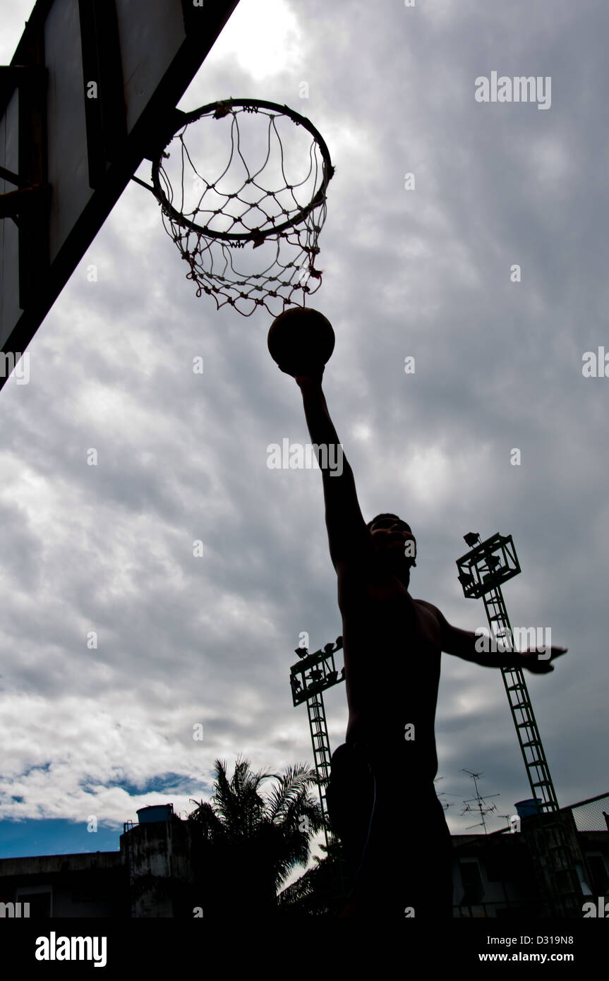 silhouette of boy dunk basketball Stock Photo