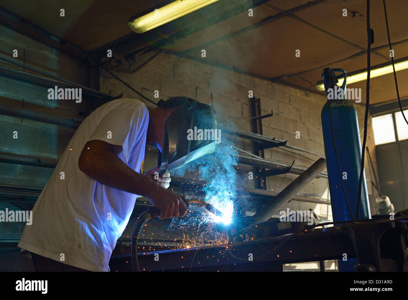 Welder in mask working on steel in factory, Europe Stock Photo