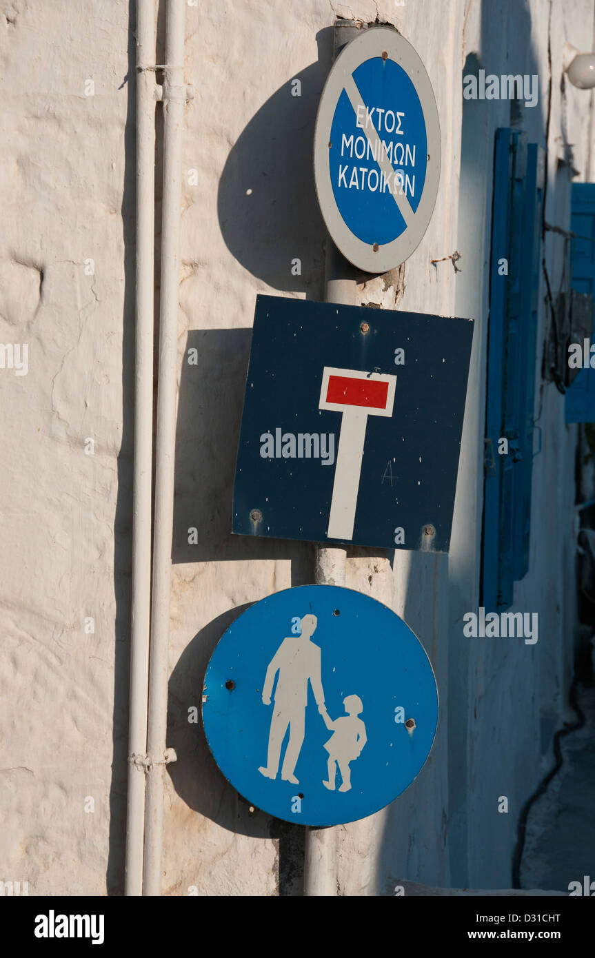 Three blue Greek road signs, pedestrians, no through road and no entry on a street corner. Stock Photo