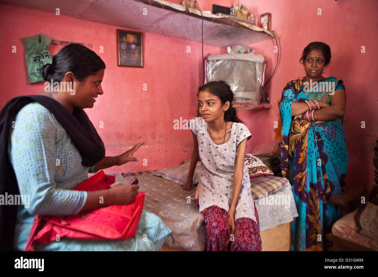 A female outreach worker from Operation Asha on a home visit to a new Tuberculosis (TB) patient. Meethapur slum, Delhi, India. Stock Photo