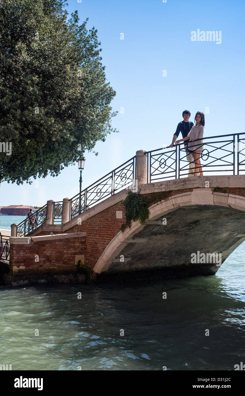 Young Couple Standing on a Bridge in Venice Italy Stock Photo