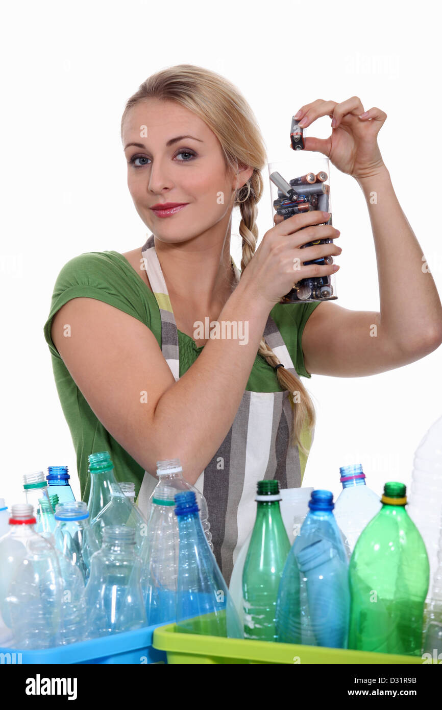 Woman recycling batteries and plastic bottles Stock Photo
