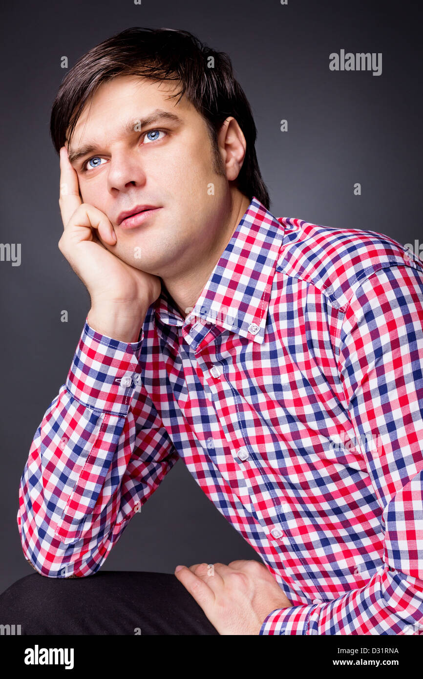 Closeup portrait of a young man thinking about a problem on grey background Stock Photo