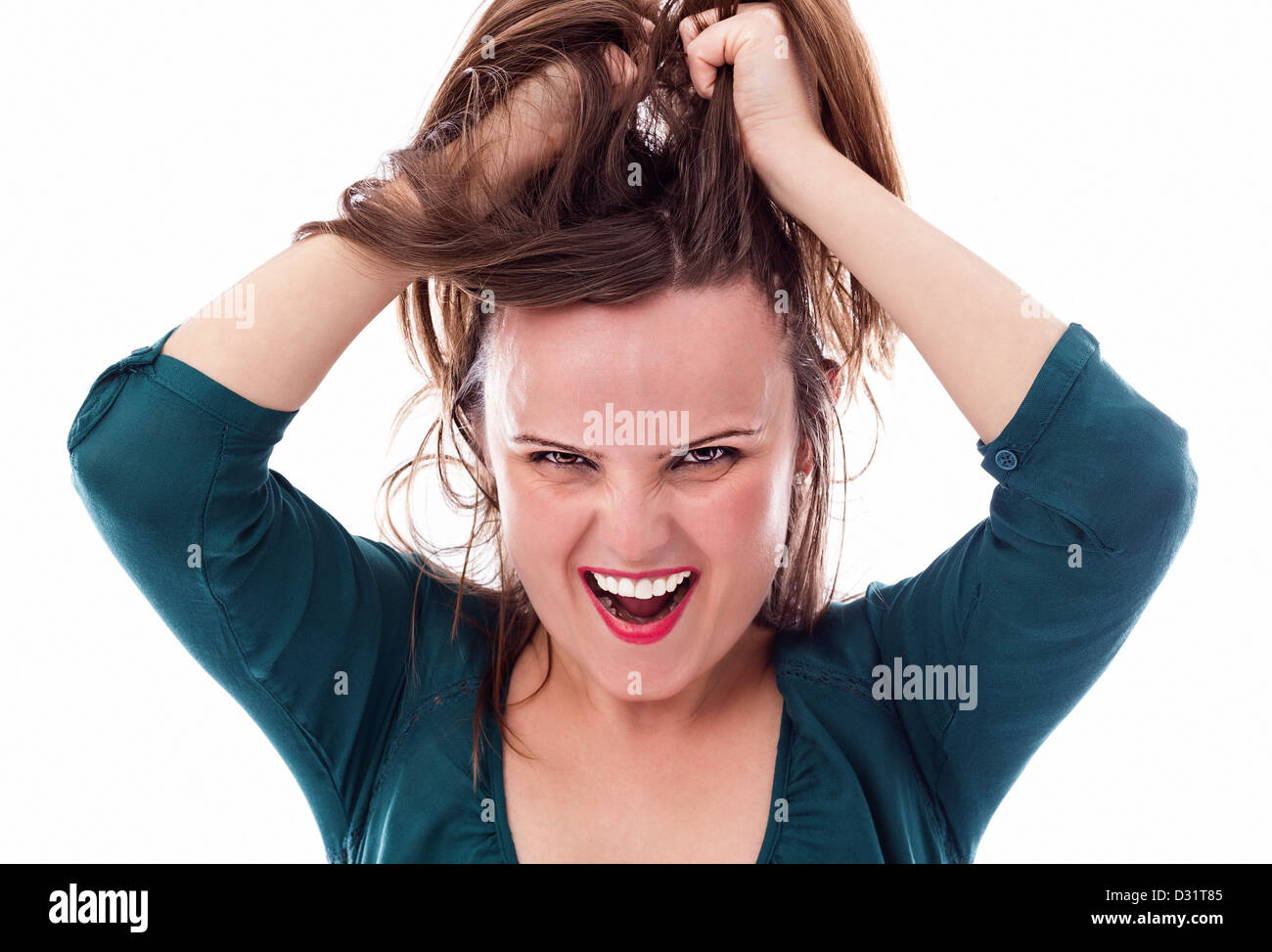 Closeup of an angry young woman pulling her hair isolated on white