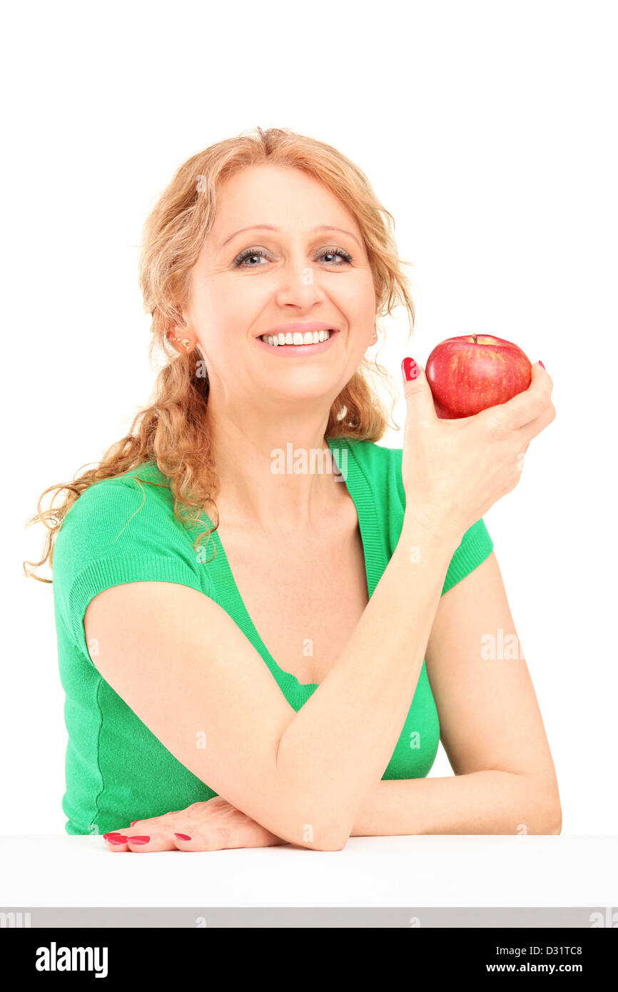 Smiling woman sitting and holding a red apple isolated on white background Stock Photo