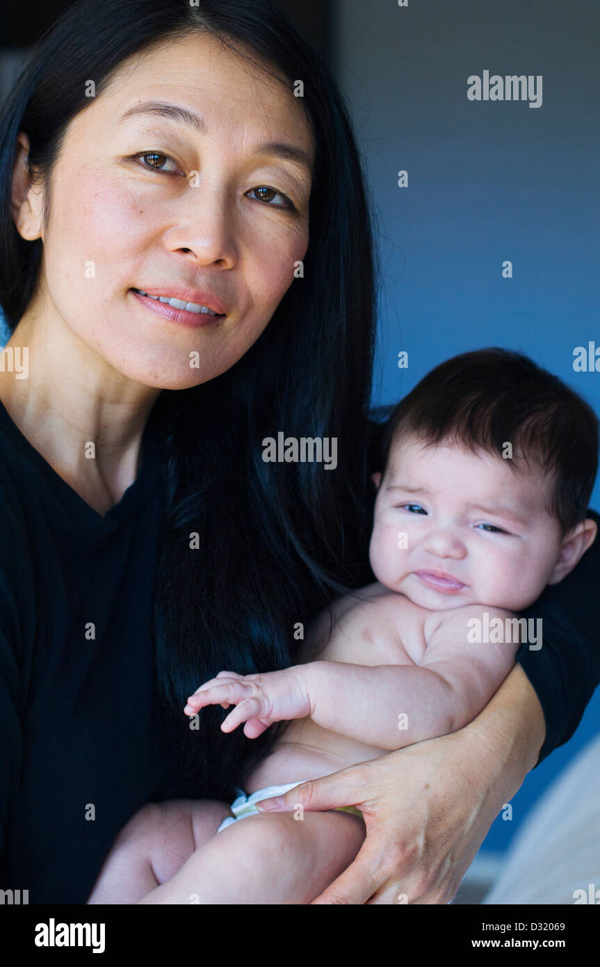Mother holding baby on bed Stock Photo
