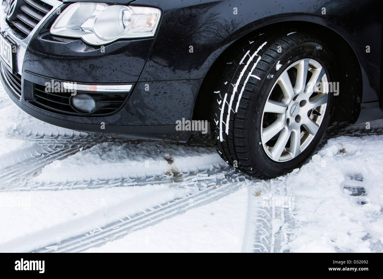Car with winter tires drives on a road with snow cover. Stock Photo