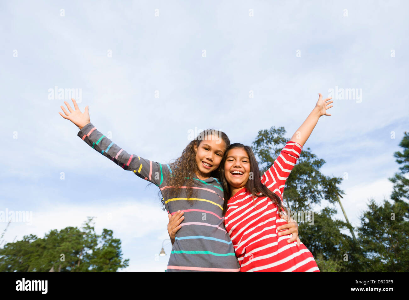 Smiling girls hugging outdoors Stock Photo - Alamy