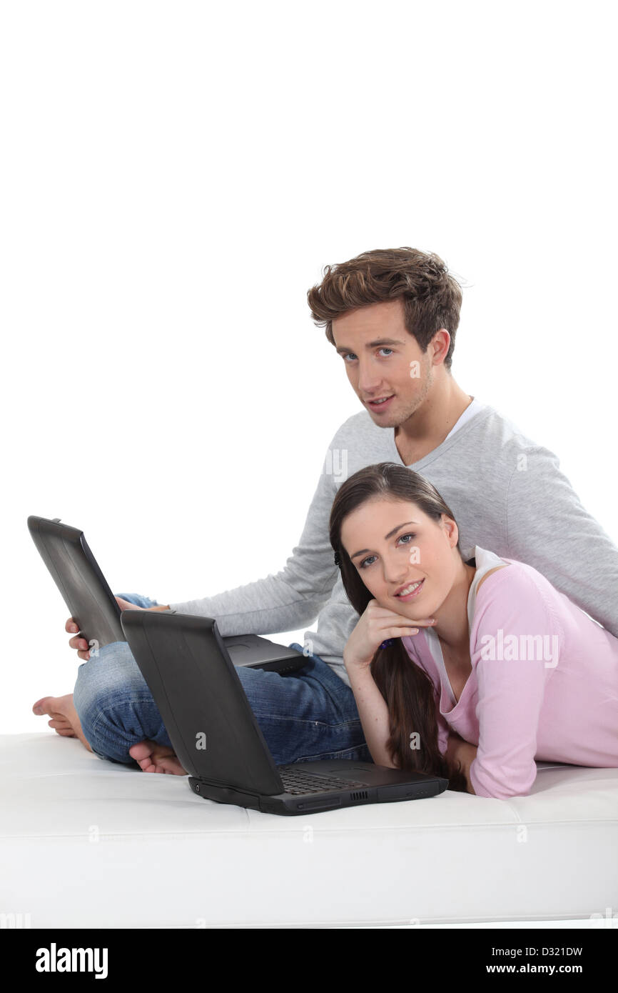 cute couple with laptop sitting on the floor Stock Photo - Alamy
