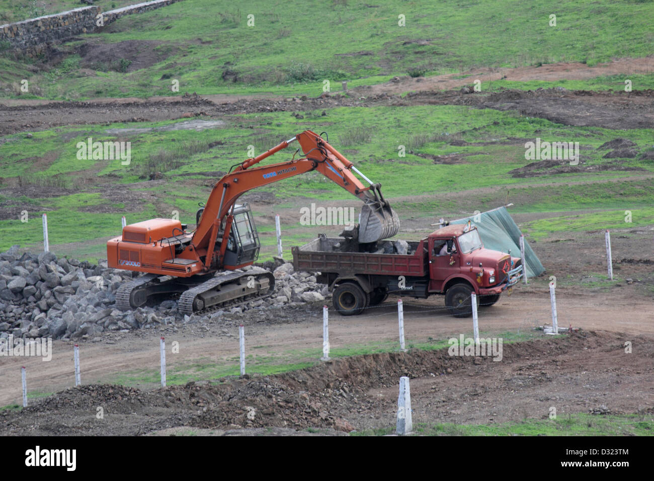 Excavator loading raw stones in truck Stock Photo - Alamy