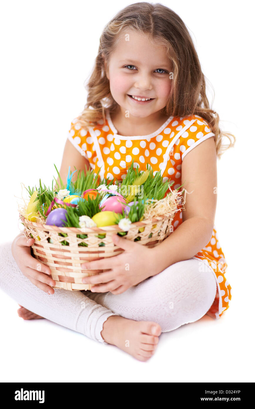 Photo of cute girl looking at camera while holding basket with colorful ...