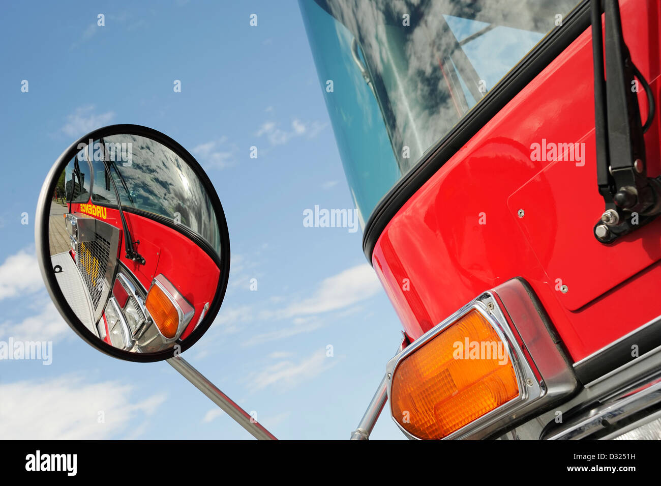 Close up of a convex mirror on a red fire truck, reflexion of the front
