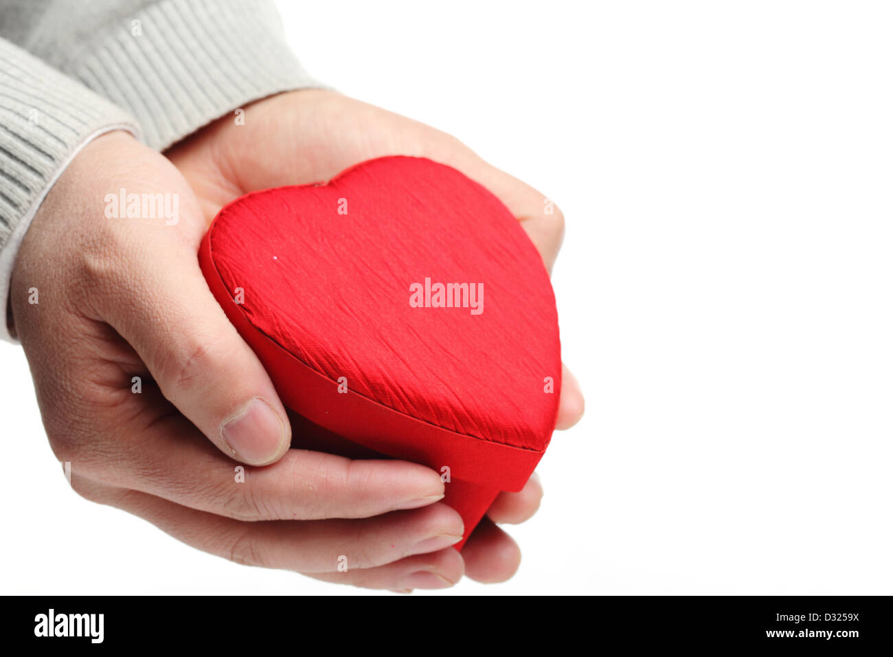 Hand hold heart shaped gift box on white. Stock Photo