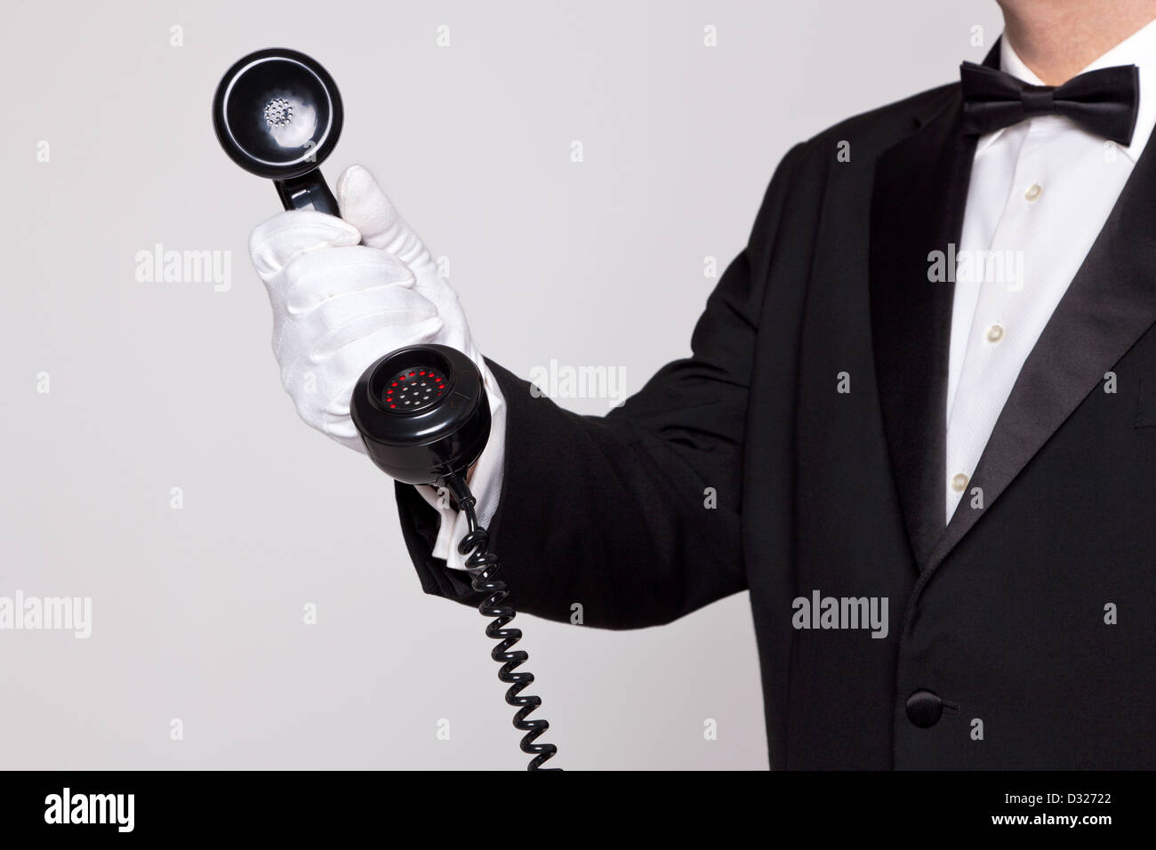 Butler Call Button Butler holding the handset from a telephone Stock Photo - Alamy