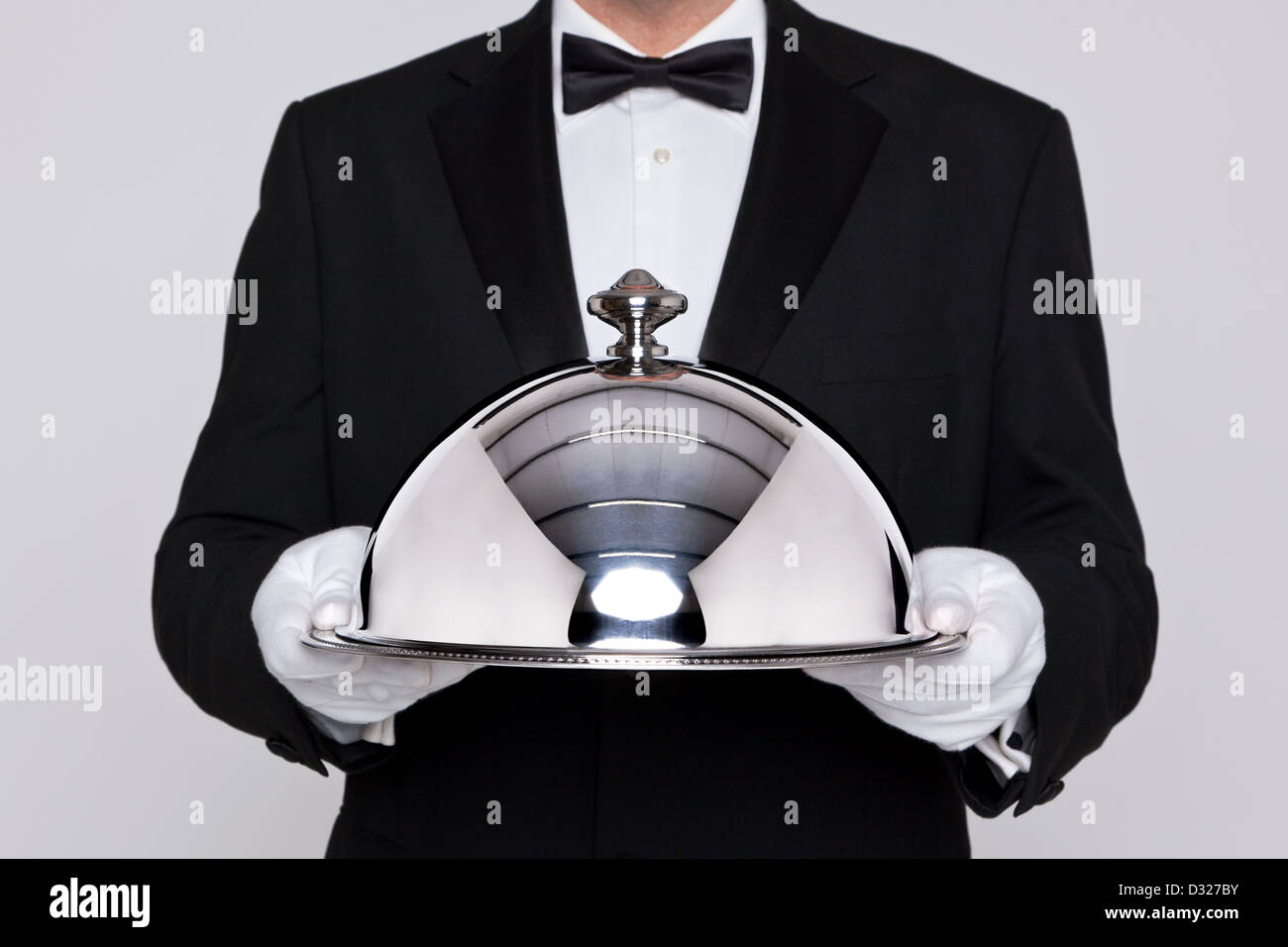 Waiter serving a meal under a silver cloche or dome Stock Photo