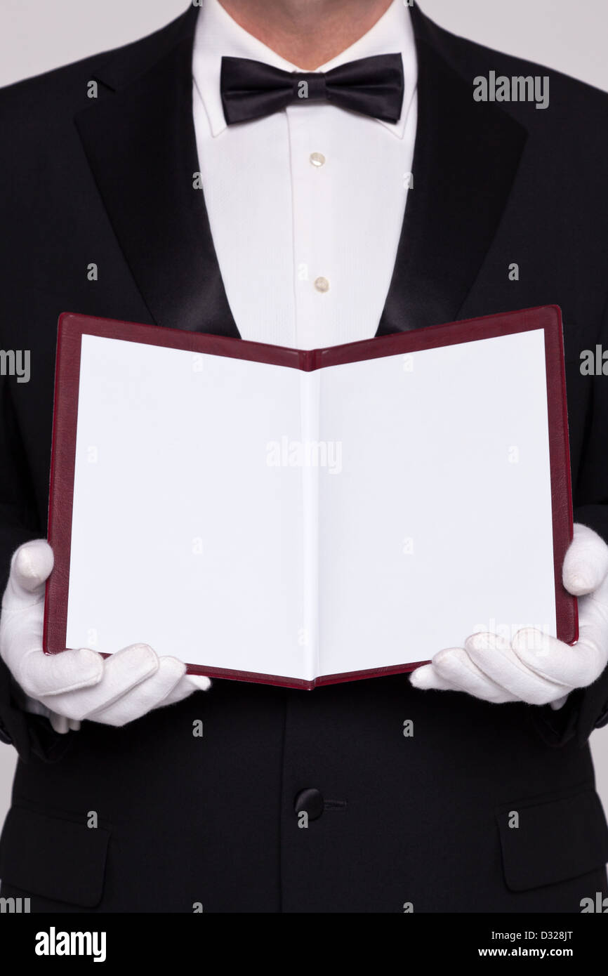 Waiter holding open a blank menu for you to add you own text for food or a wine list. Stock Photo