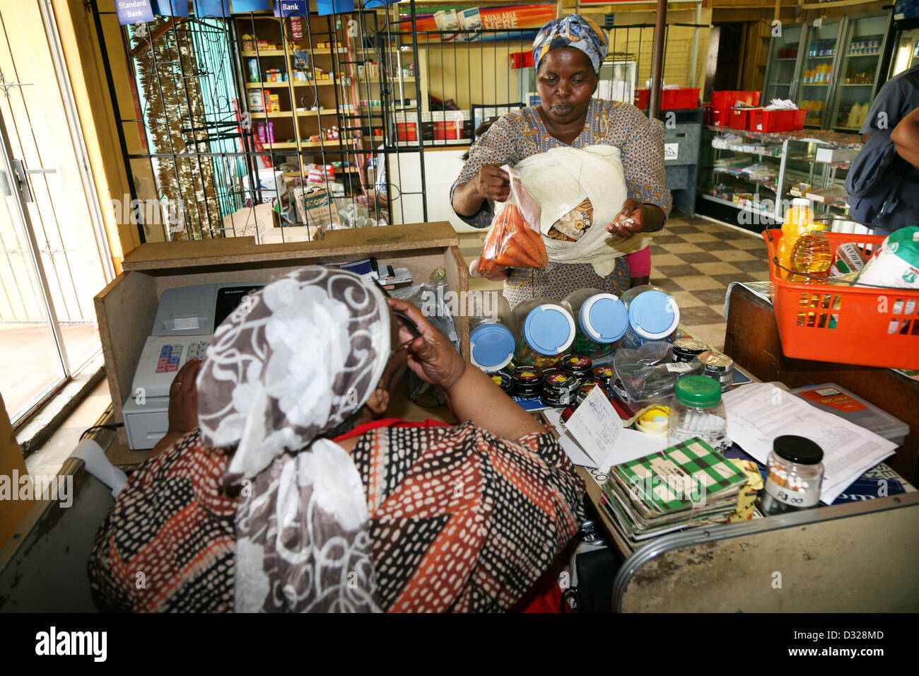 African customers purchase consumer items at a small bussiness in Hamburg, South Africa Stock Photo
