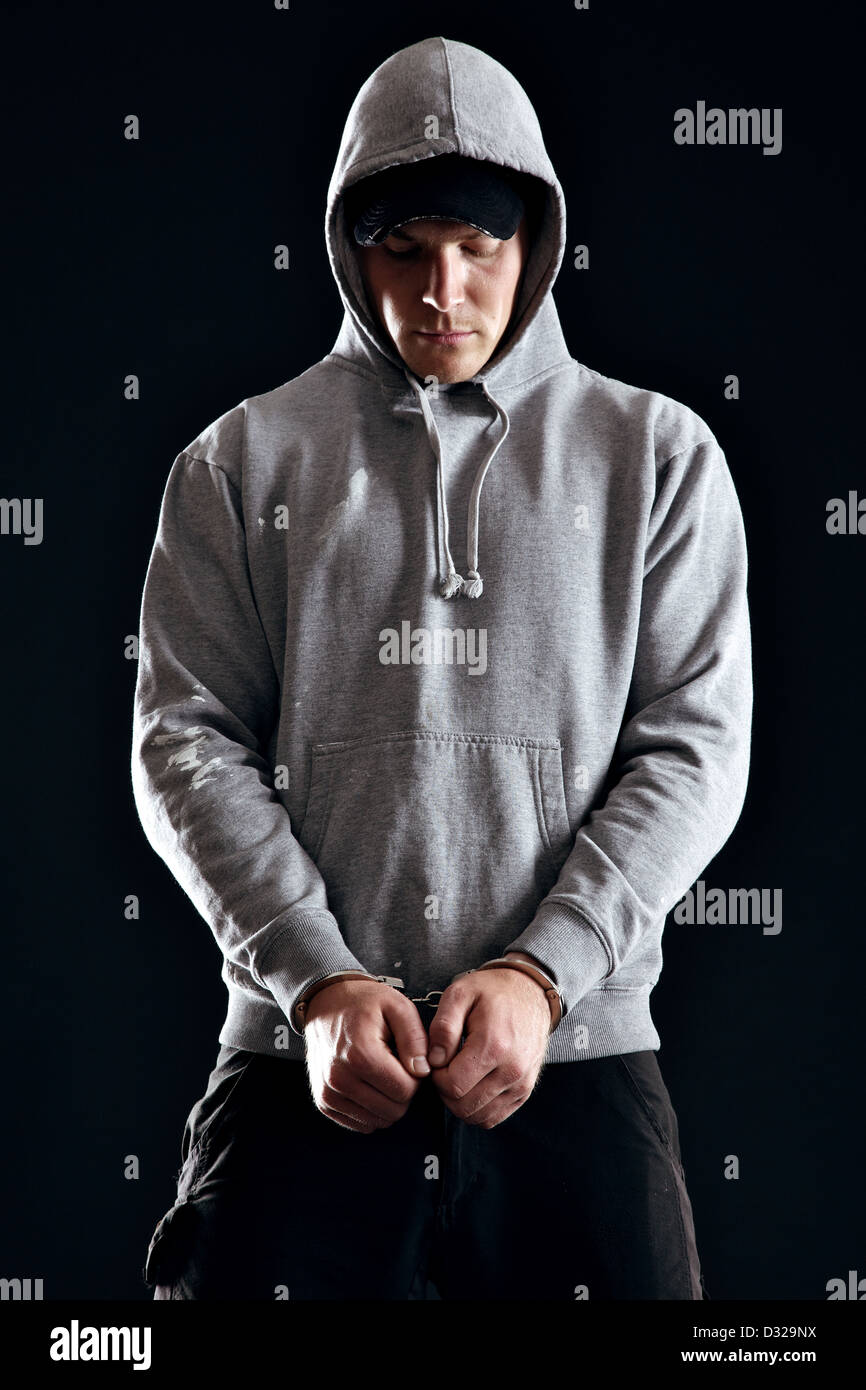 Handcuffed offender wearing a hooded sweatshirt Stock Photo