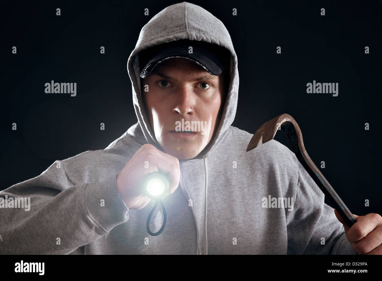 Burglar with crowbar and a flashlight ready for work Stock Photo Alamy