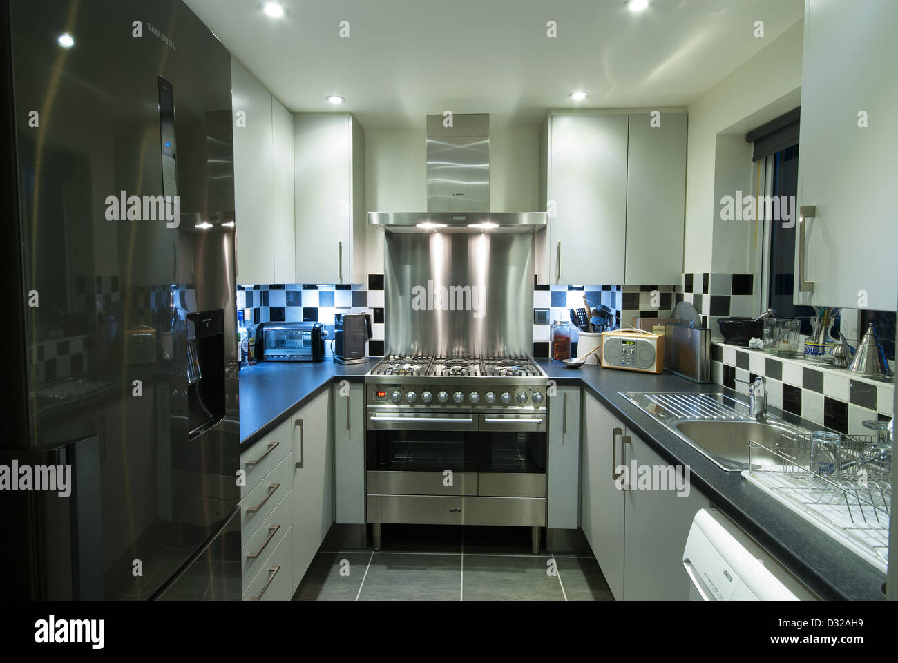A small, modern domestic kitchen with a stainless steel range cooker. UK, 2013. Stock Photo