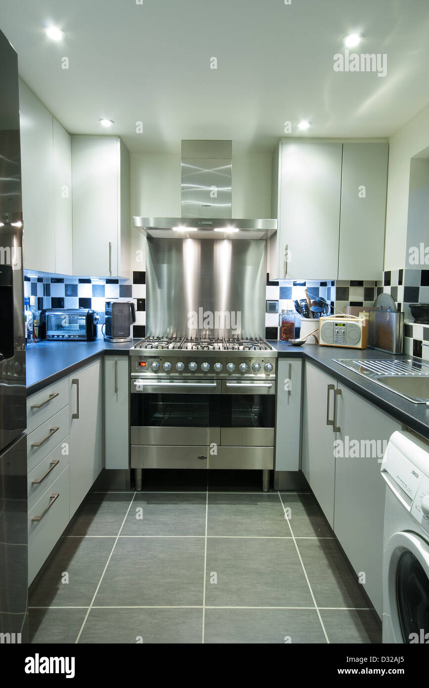 A small, modern domestic kitchen with a stainless steel range cooker. UK, 2013. Stock Photo