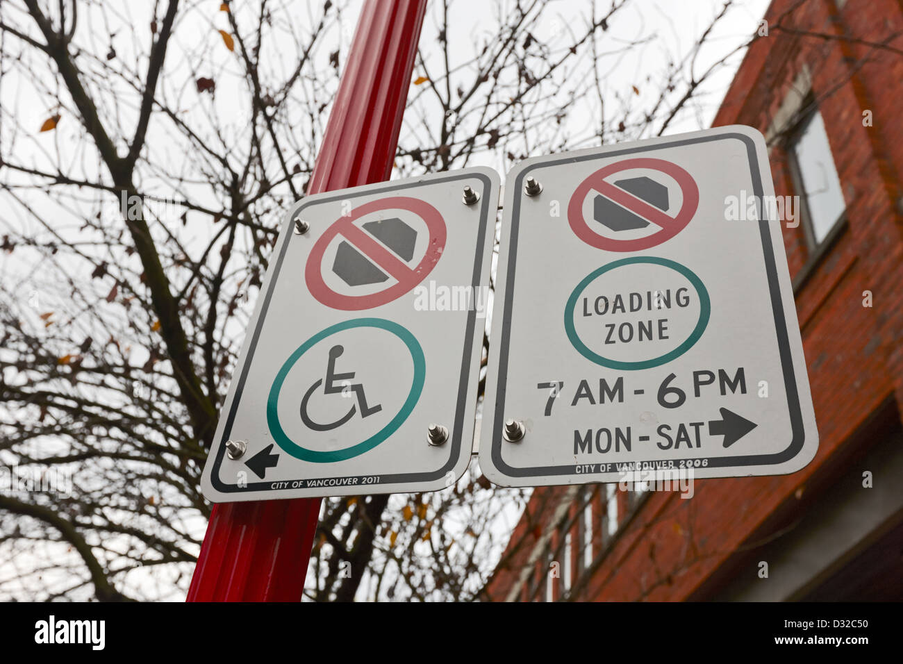 no parking loading zone and disabled parking signs chinatown Vancouver BC Canada Stock Photo
