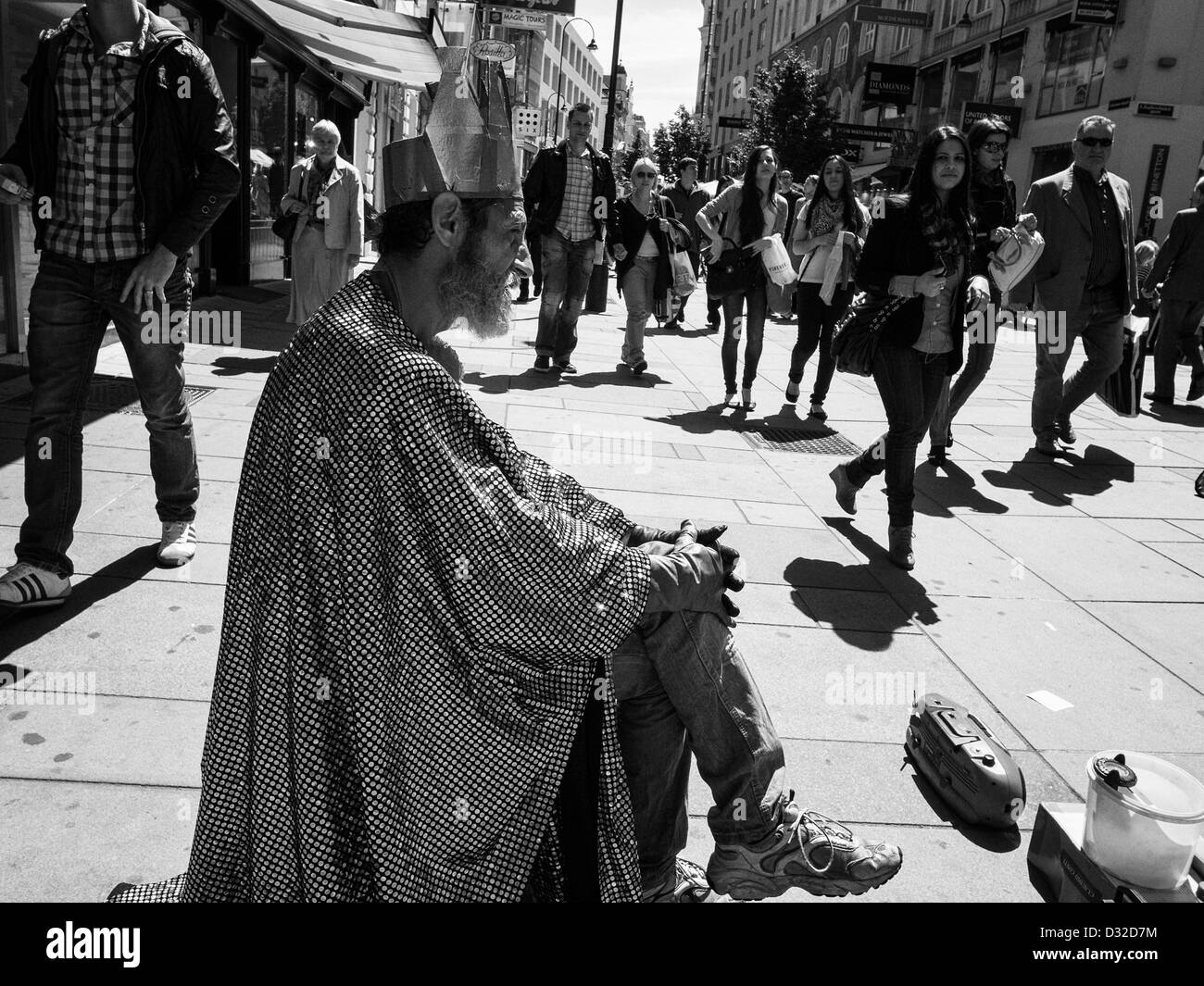 old clown on a street with kings crown and shiny cloak Stock Photo
