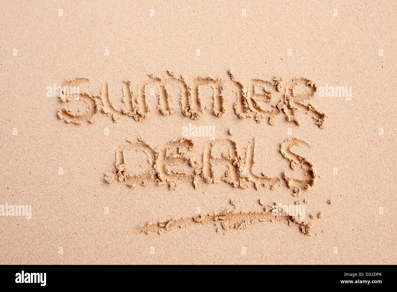 summer deals written in the sand on a beach Stock Photo