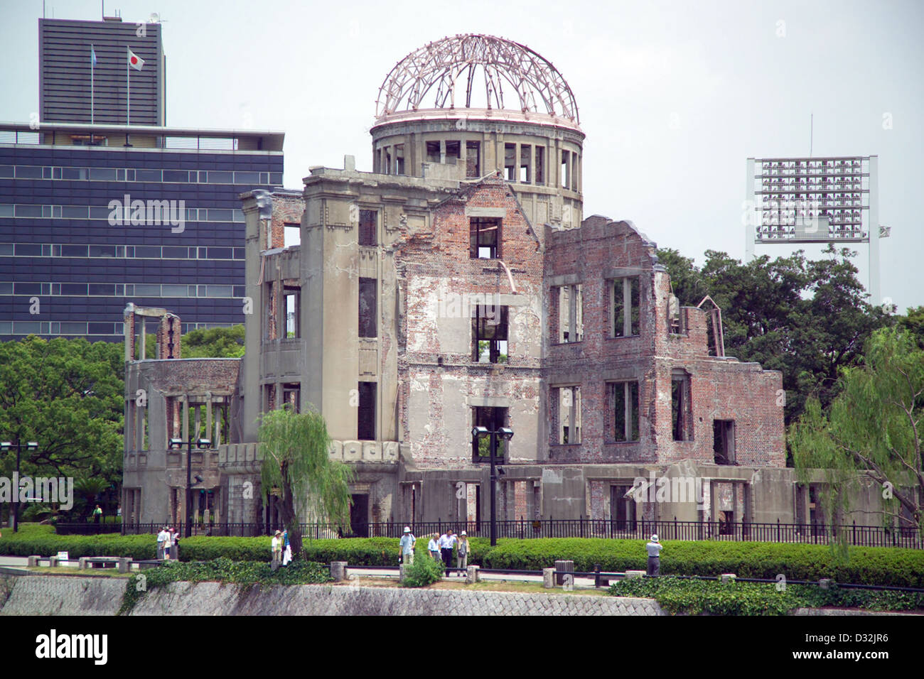 Atomic bomb dome (Genbaku Dome), Hiroshima, Japan. Lighting tower at top right is at Hiroshima Shimin Kyujo (Hiroshima Citizens' Stock Photo