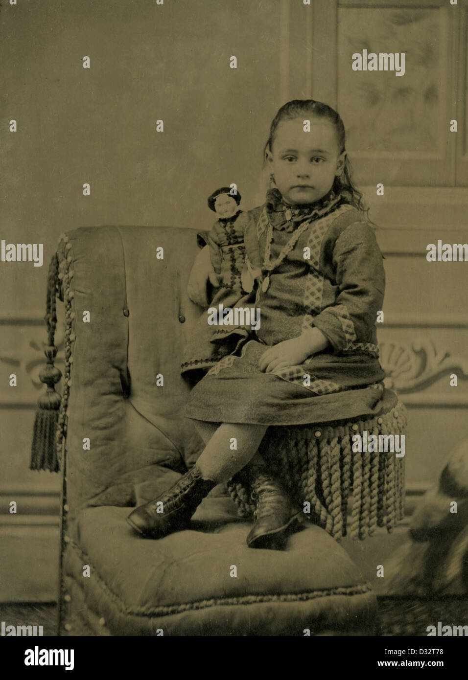 Circa 1870s tintype photograph, a little girl with her Victorian doll. Stock Photo