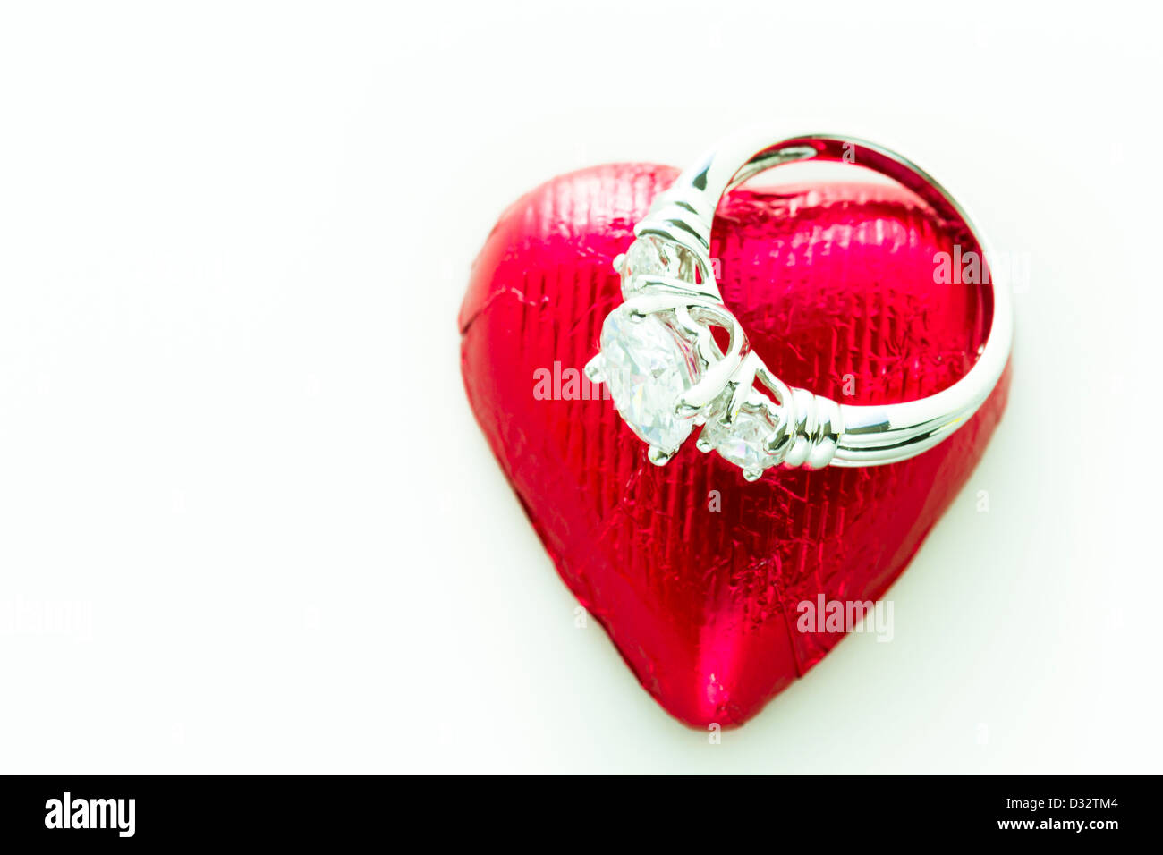 Heart shape chocolate candies wrapped in red foil for Valentine's Day. Stock Photo