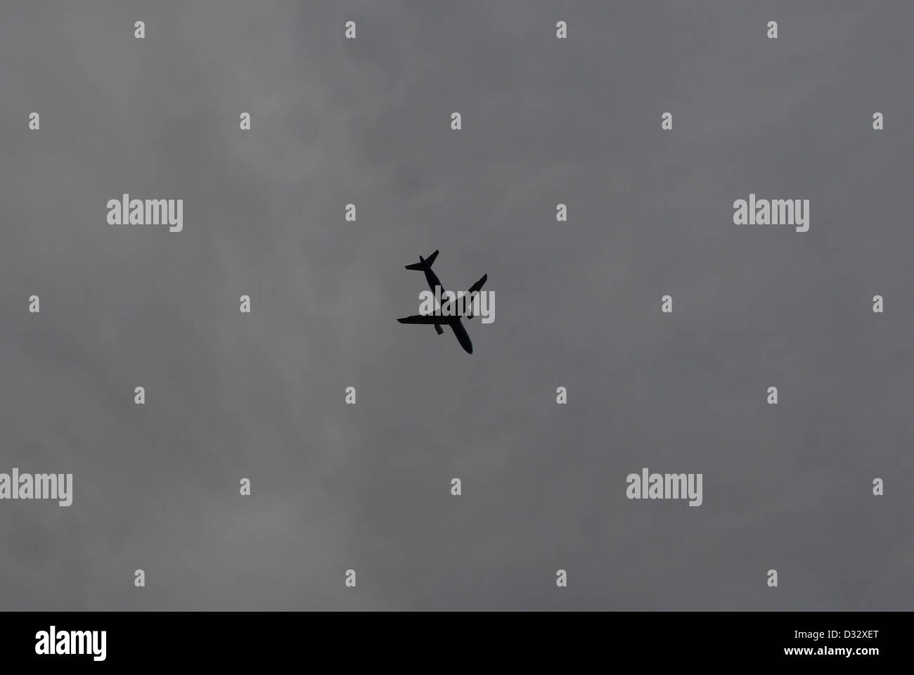 jet airliner silhouetted against a heavy grey sky Stock Photo - Alamy