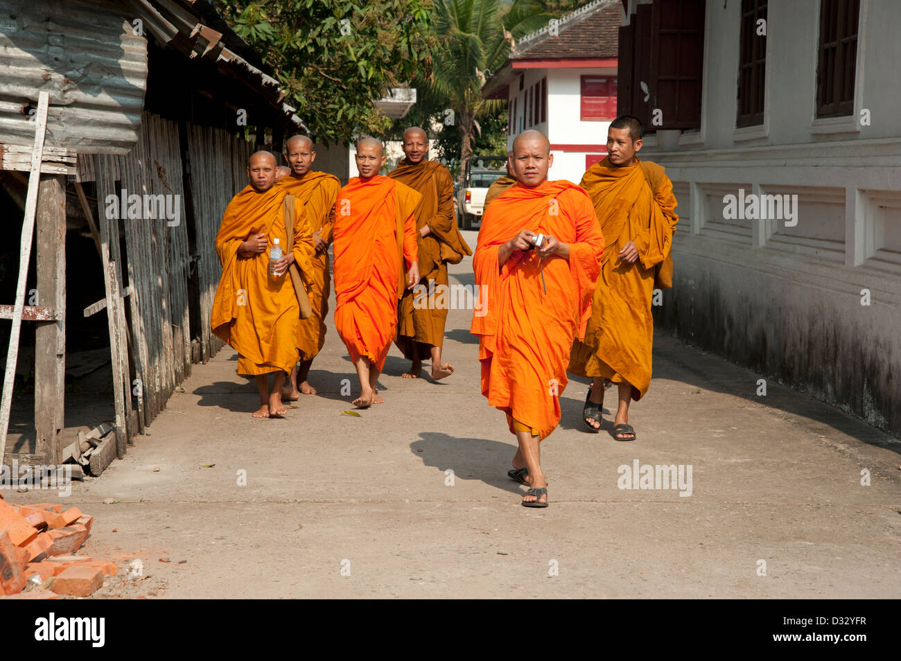 Buddhist monks wearing saffron robes walking through temple grounds
