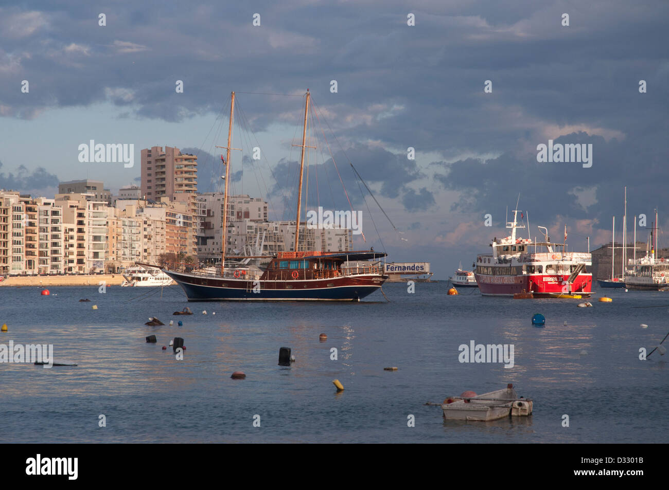 harbour scene, Sliema, Malta, Valetta, pleasure boats, masts, calm water, grey sky, rainy, grey clouds,promenade, buildings Stock Photo