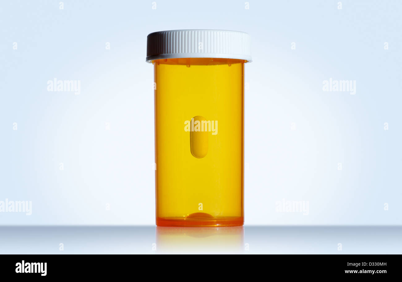 Pill floating in empty prescription bottle Stock Photo