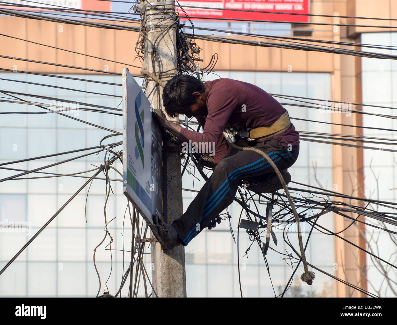 An electrician works on a tangle of electric wires in Kathmandu, Nepal