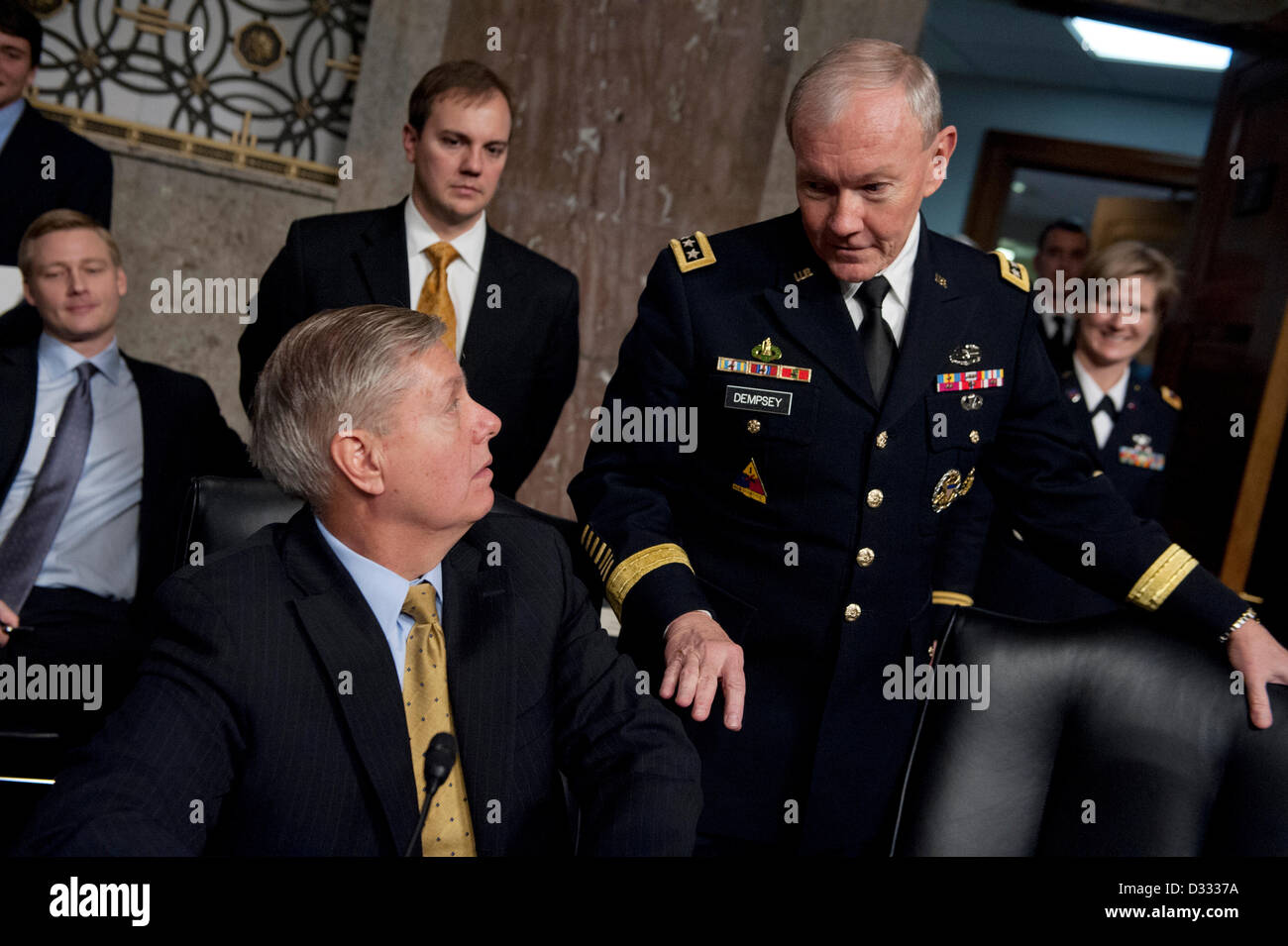 Washington DC, USA. 7th February 2013. Chairman of the Joint Chiefs General Martin Dempsey speaks with Senator Lindsey Graham during a break in the hearing of the Senate Armed Services Committee on the Defense Department’s response to the attack on the US Consulate in Benghazi, Libya February 7, 2013 in Washington, DC. Credit:  Planetpix / Alamy Live News Stock Photo