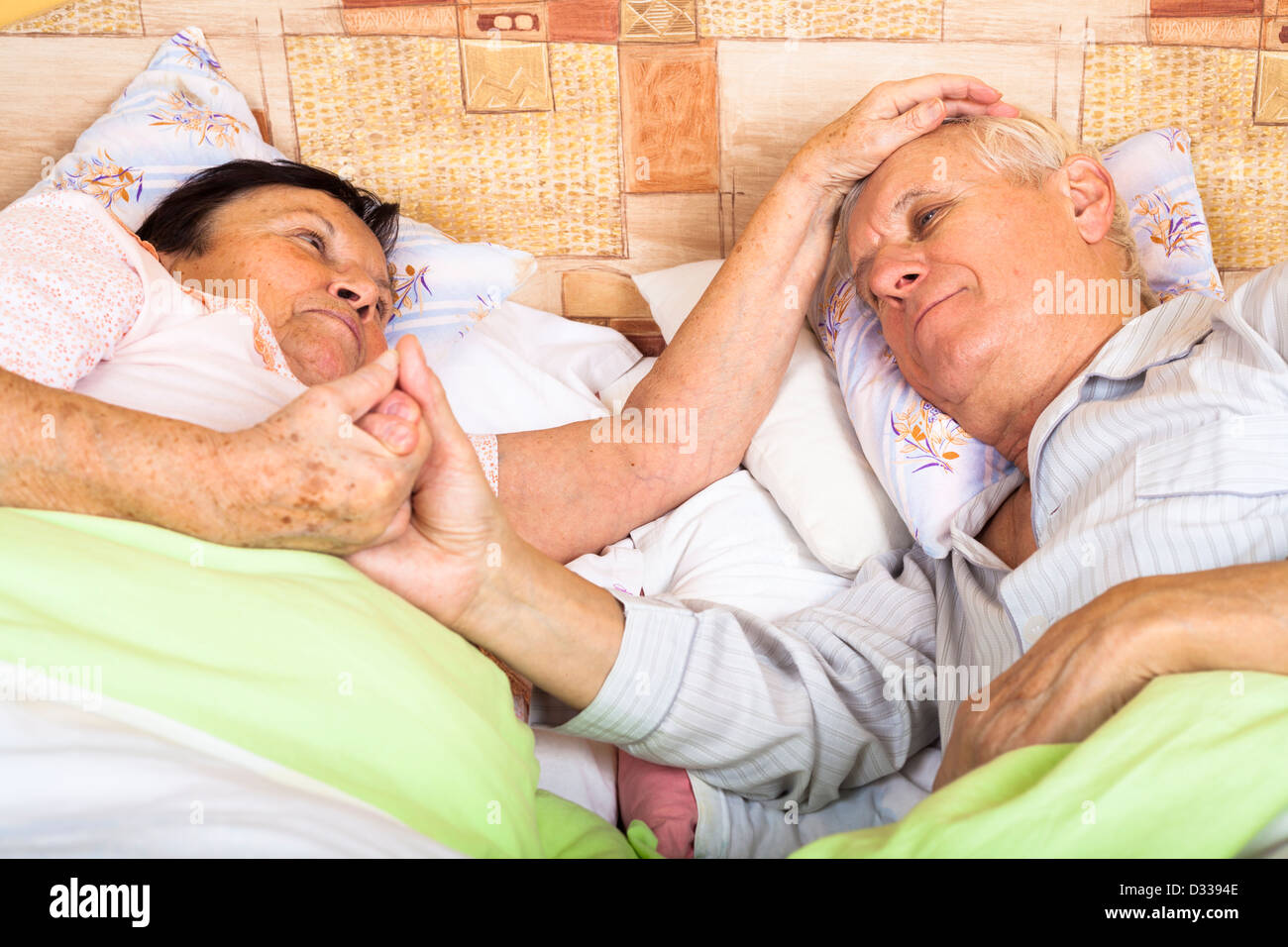 Close up of loving senior couple relaxing in bed. Stock Photo