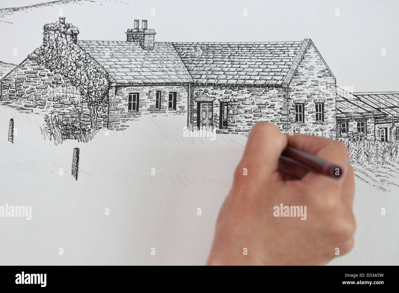 Artist drawing / sketching in studio pen and ink line drawing of old Scottish cottage architecture in Orkney islands. Stock Photo