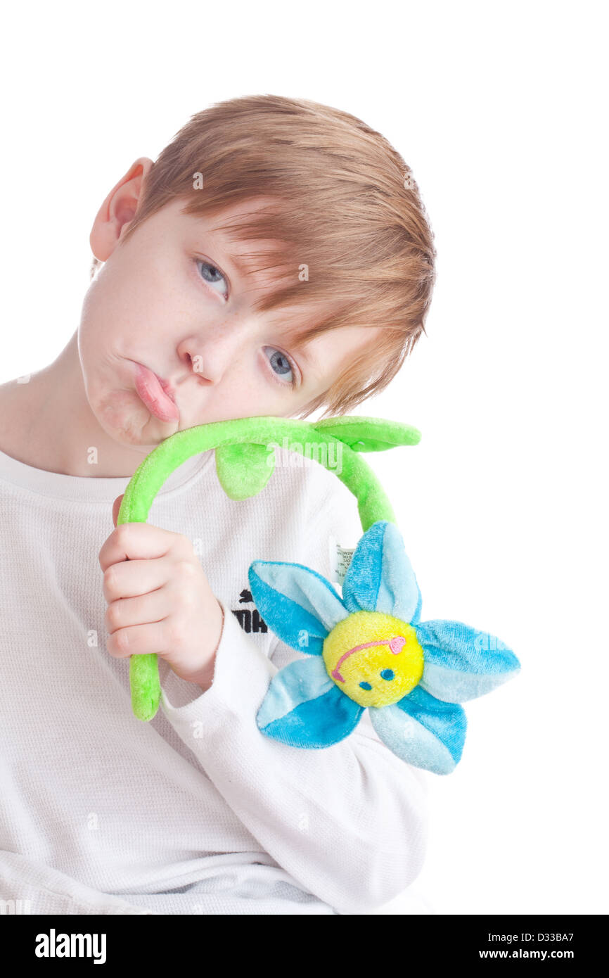 frowning depressed looking boy with wilting toy flower Stock Photo