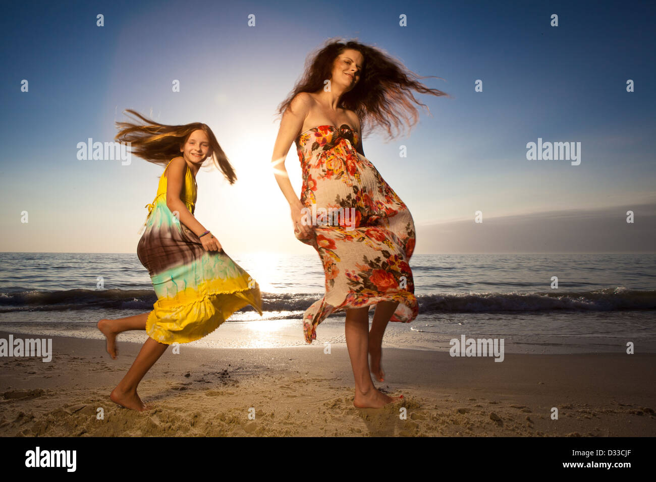 Mother and daughter jumping and dancing on beautiful beach Stock Photo ...
