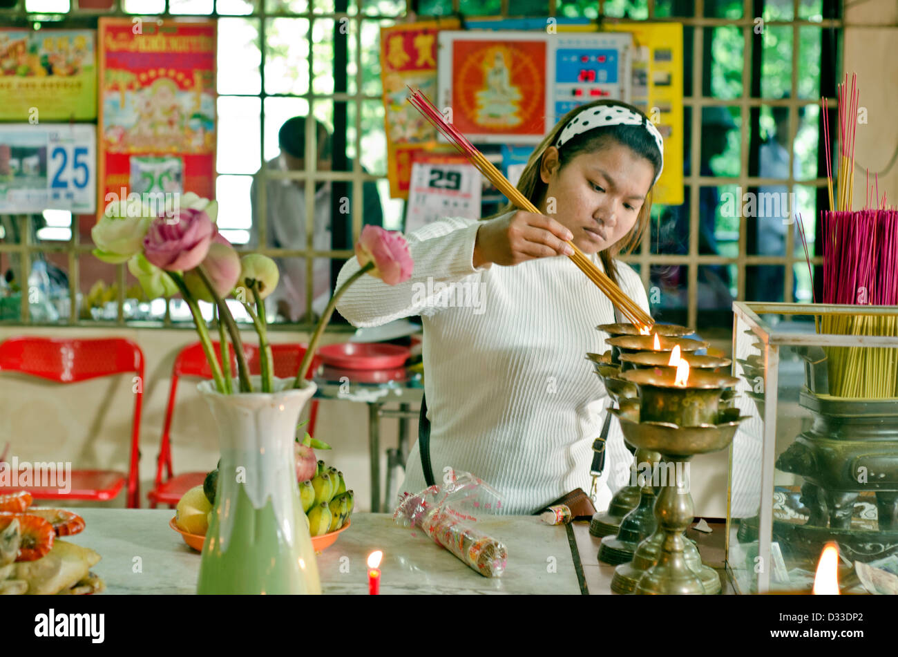 Woman places flowers at Wat Phnom shrine ,Phnom Penh,Cambodia Stock Photo