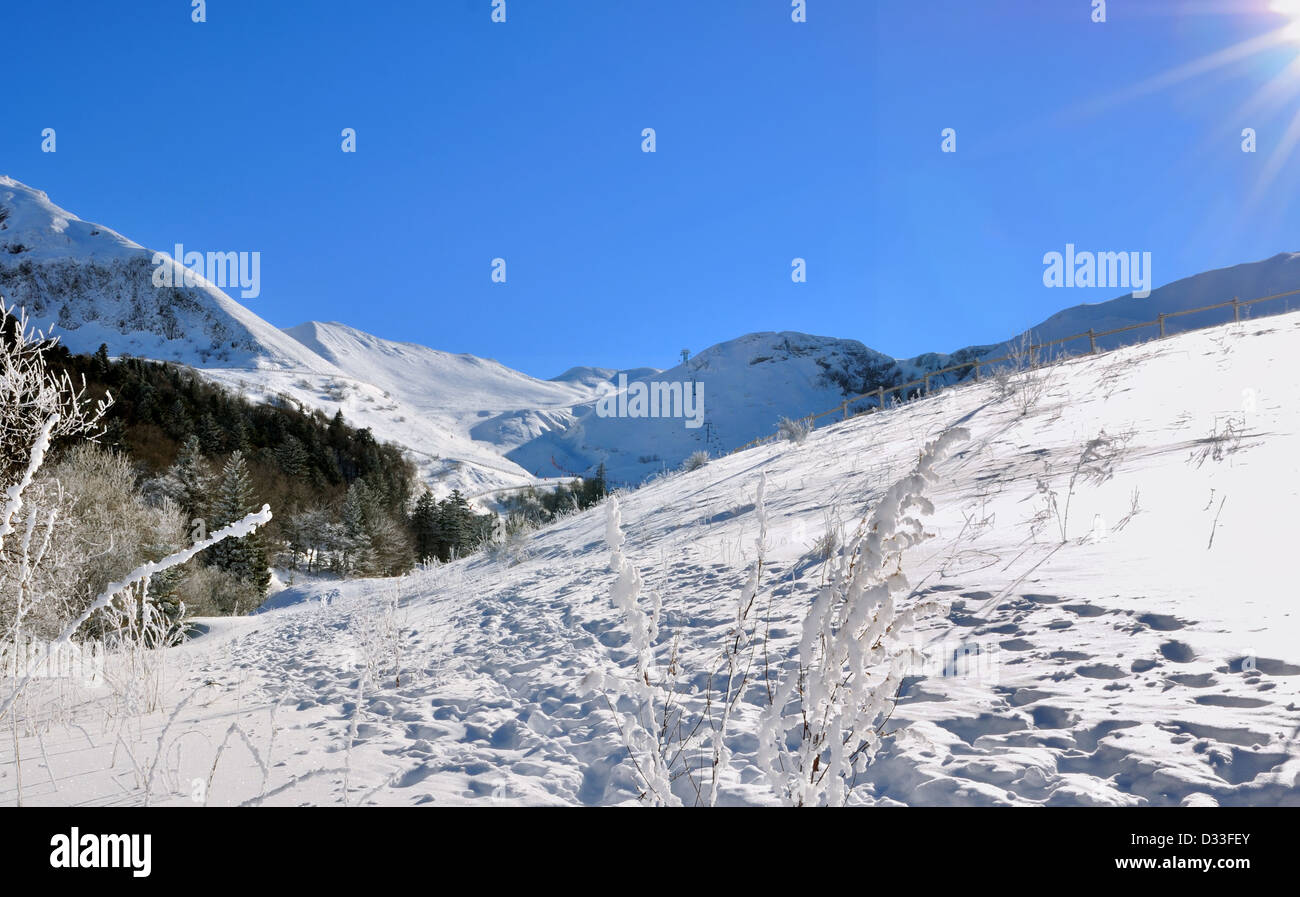 traces on hiking trail in snowy mountain under blue sky and sun Stock Photo