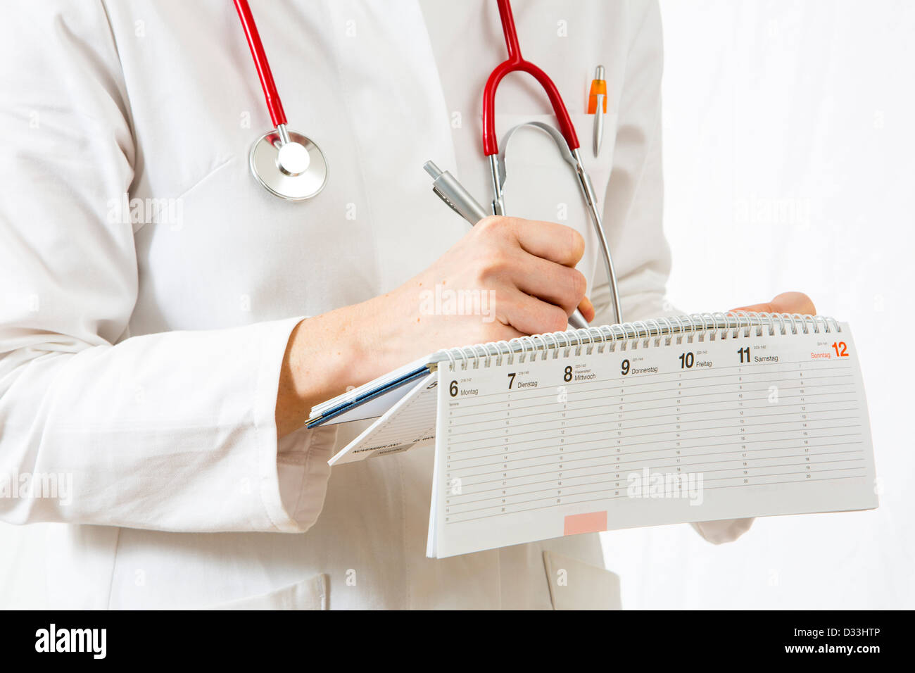Symbolic image medicine. Doctor is writing down appointments in a calender. Stock Photo