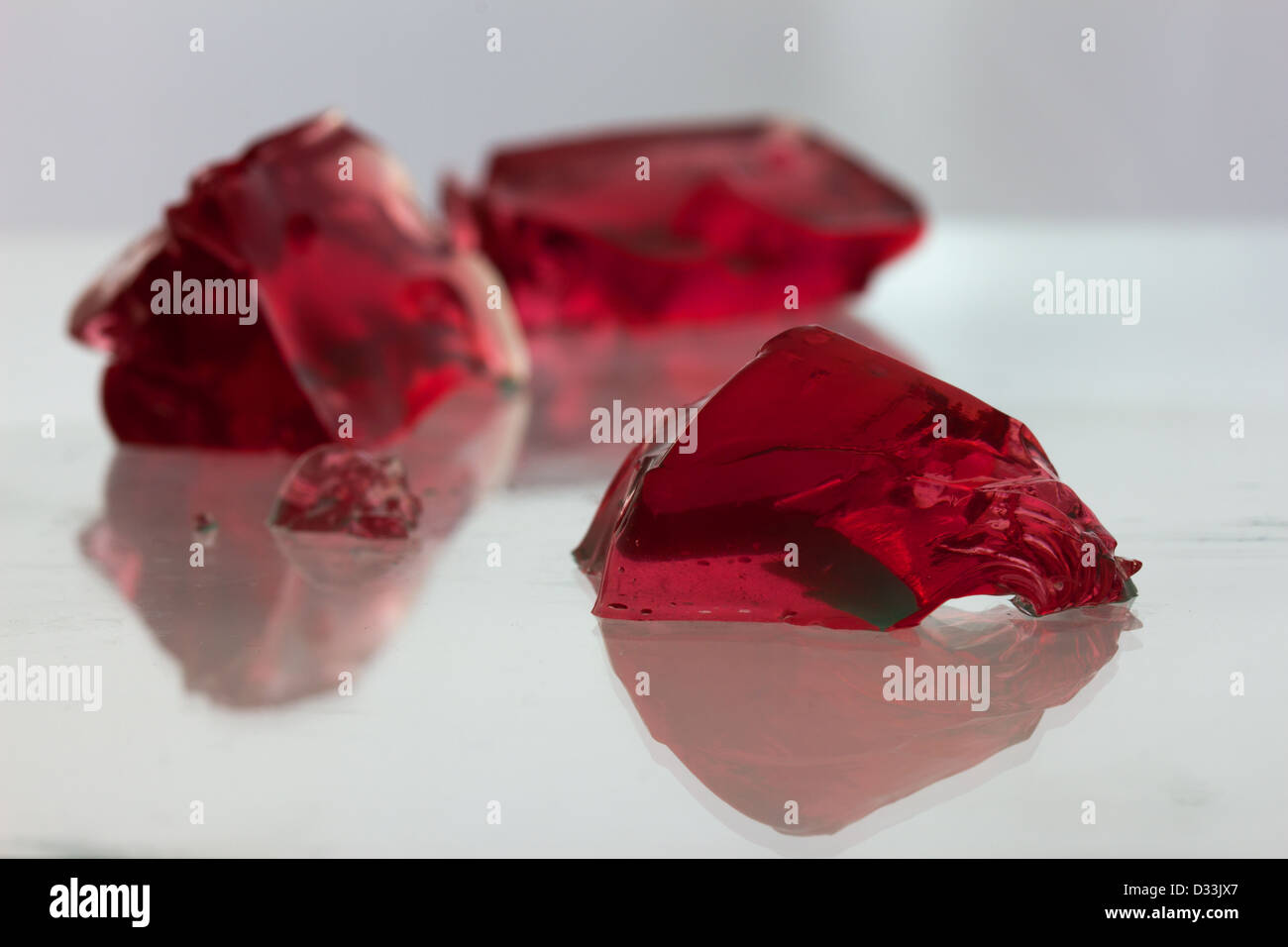 Red jelly blobs on a glass reflective surface / landscape Stock Photo