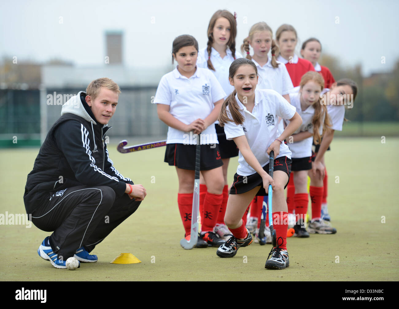 A games teacher instructs girls during hockey practice at Pates Grammar