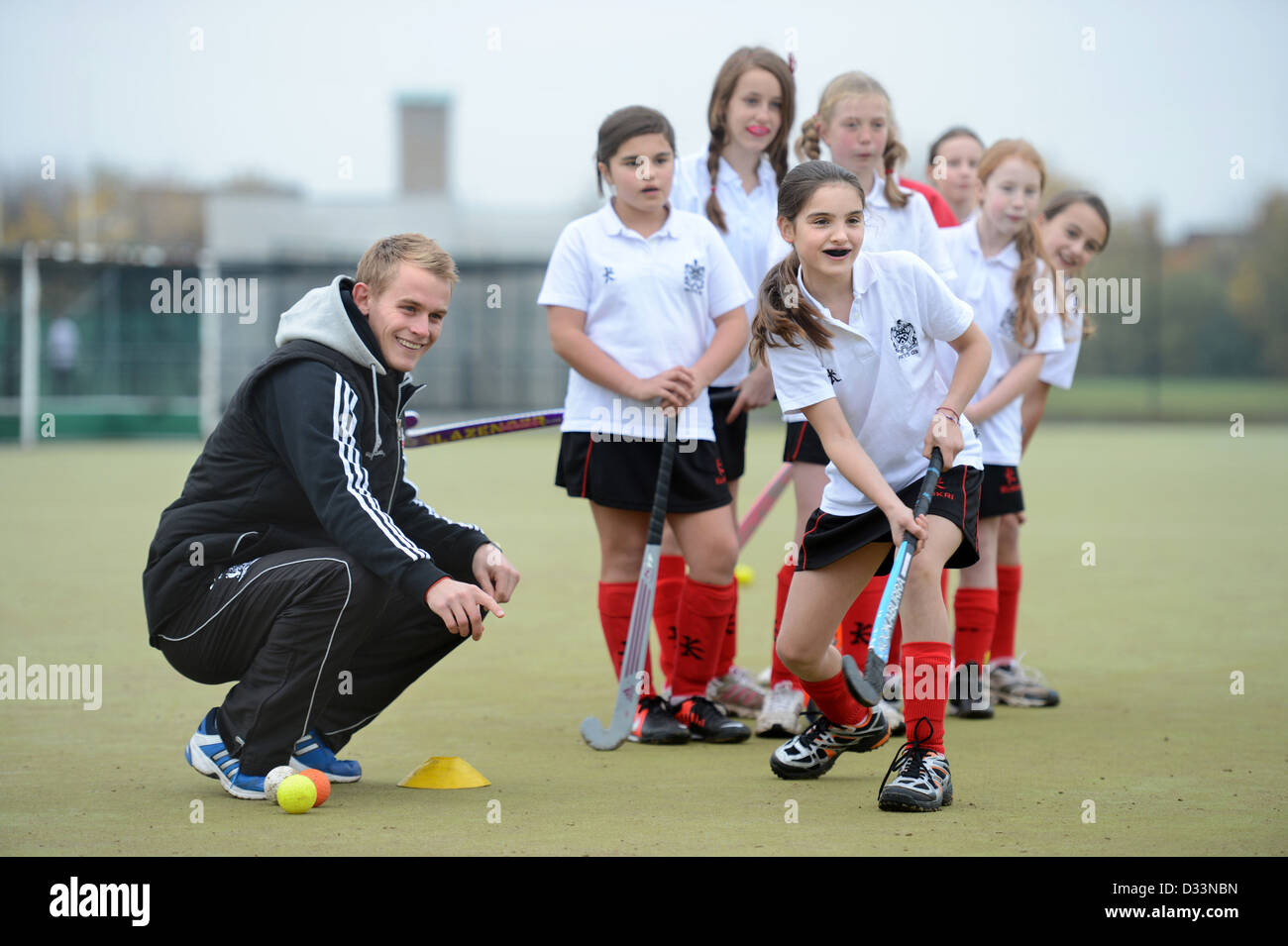 A games teacher instructs girls during hockey practice at Pates Grammar School in Cheltenham, Gloucestershire UK Stock Photo