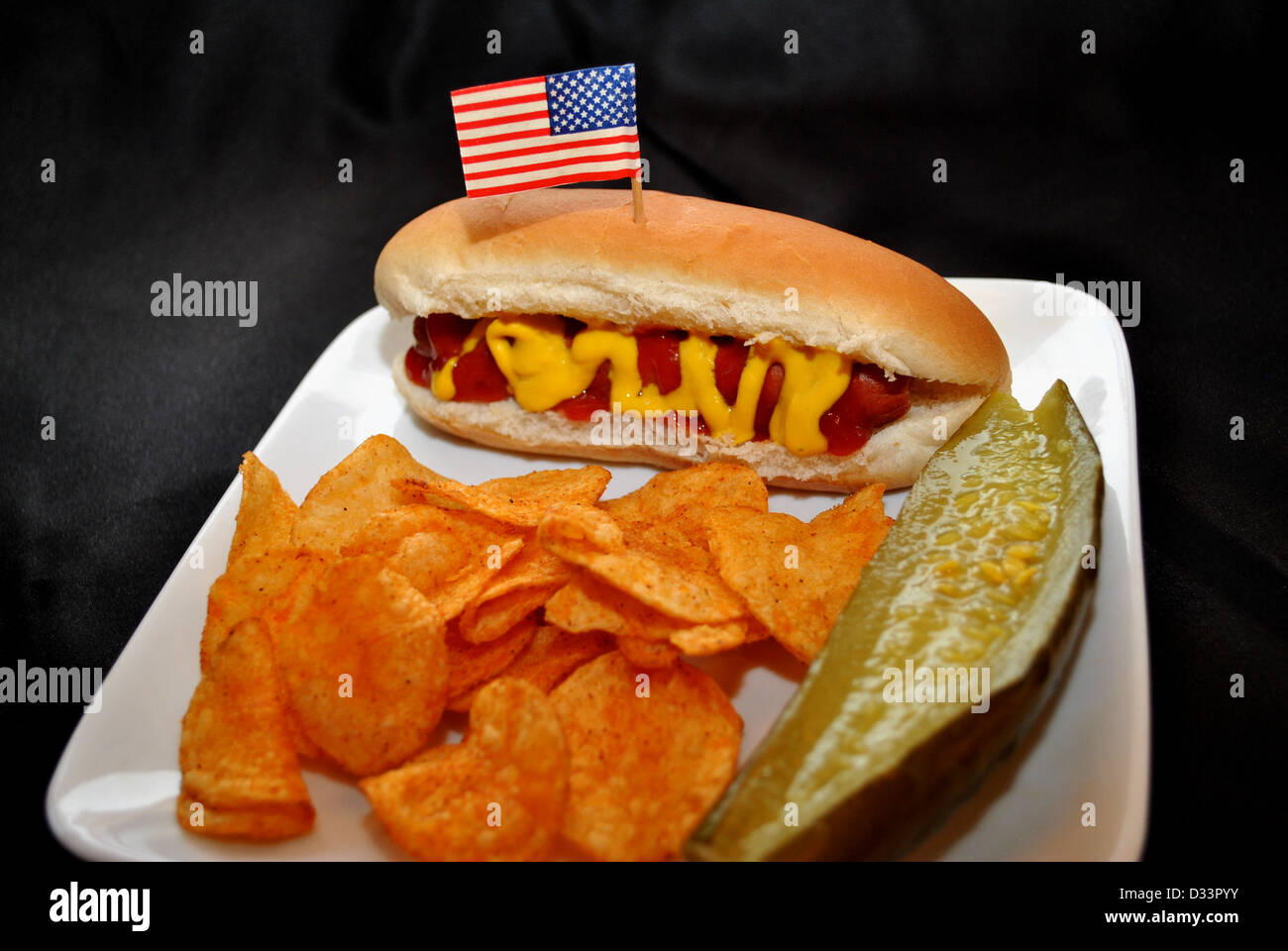American Picnic Meal-Hotdog with Catsup, Potato Chips and a Pickle Stock Photo